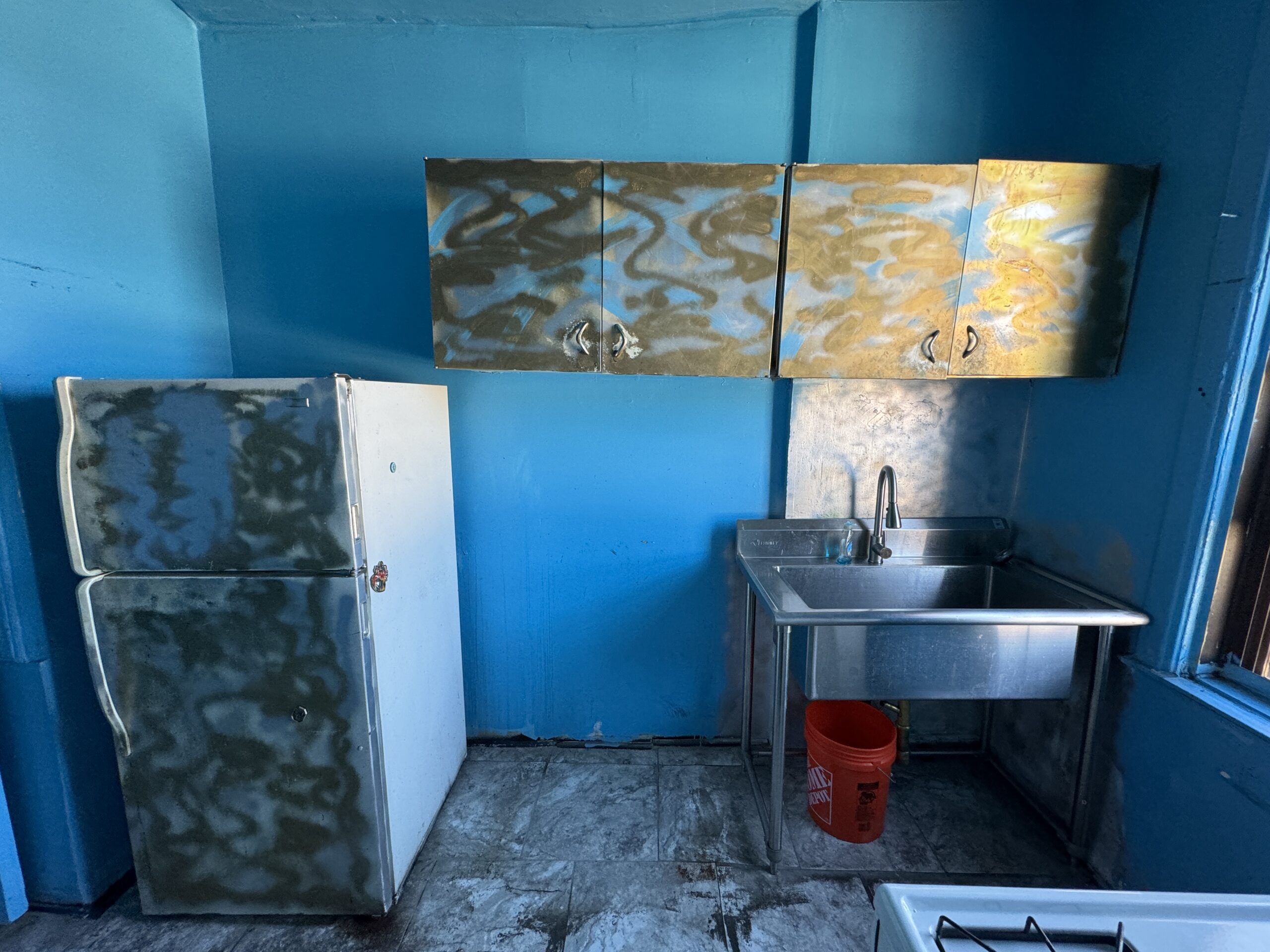 Kitchen before renovation, with worn cabinetry and unfinished interior surfaces