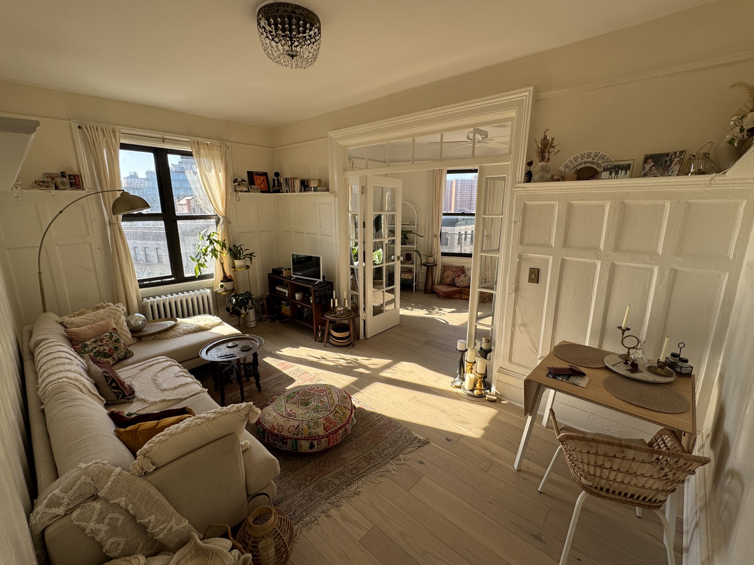 Completed restored living room with original paneling, French doors and light wood flooring