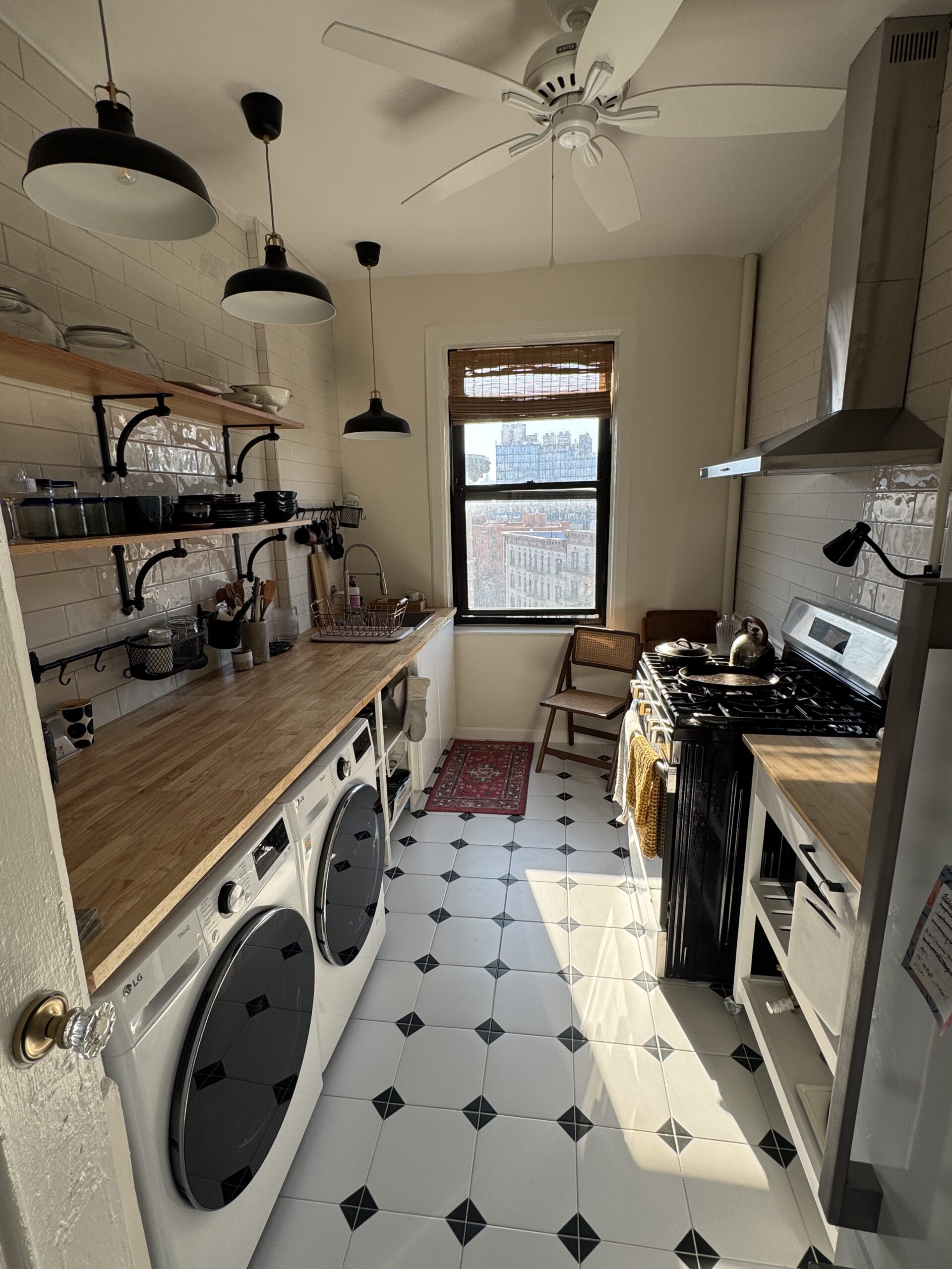 Completed galley kitchen with subway-tile walls, wood counters and open shelves