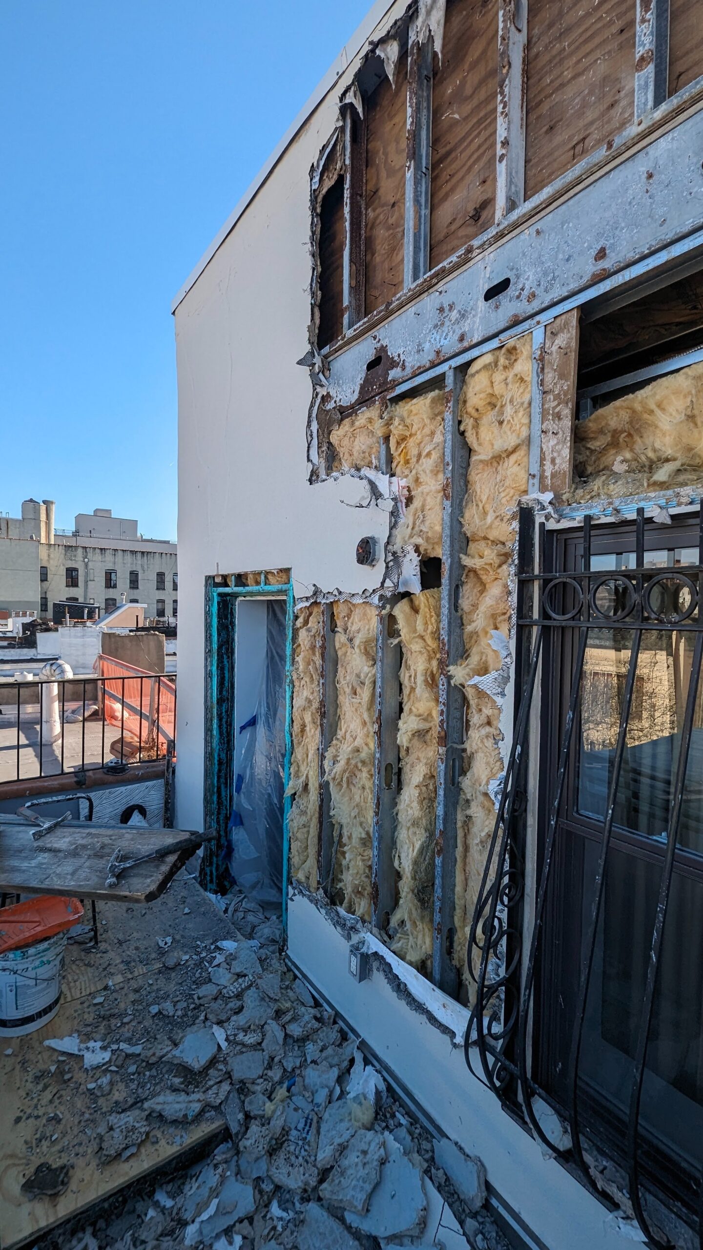 Exterior wall opened for insulation and building-envelope repair